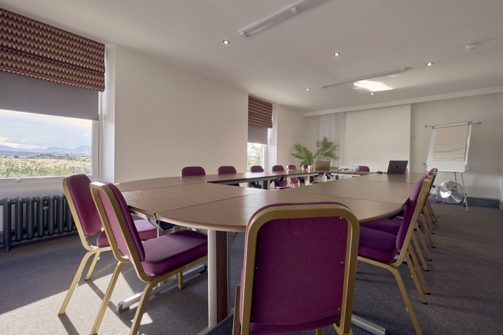 Blake Conference Room at the Melbreak, with a large conference table, projector screen and mountain views