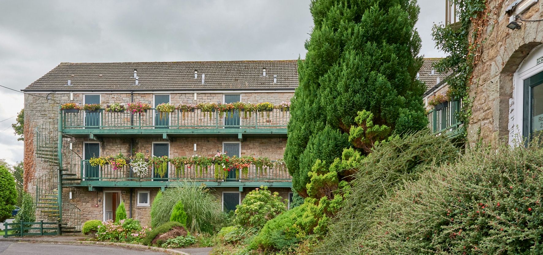 External view of a building at the Melbreak hotel, with flowers lining the balconies