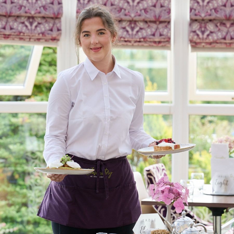 Waiting staff with plates of food in the Conservatory restaurant