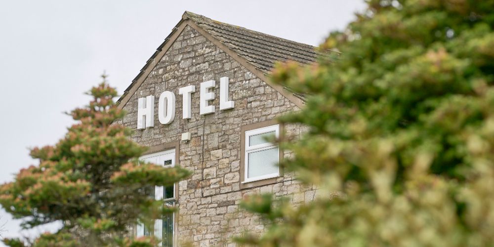 Hotel sign of the Melbreak Hotel seen through trees